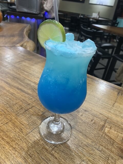 Blue cocktail with lime garnish