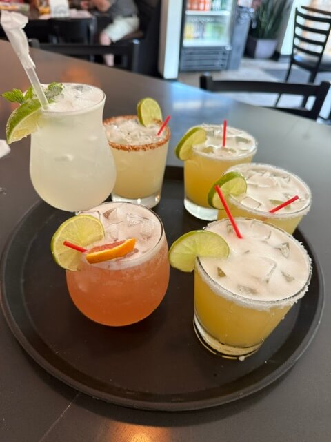 6 unique cocktails on a tray garnished with limes2